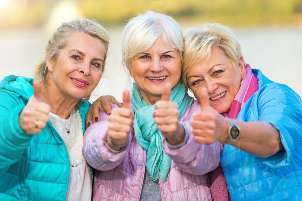 three middle aged women happily give a thumbs up to indicate they know the answer to What is Living Aware?