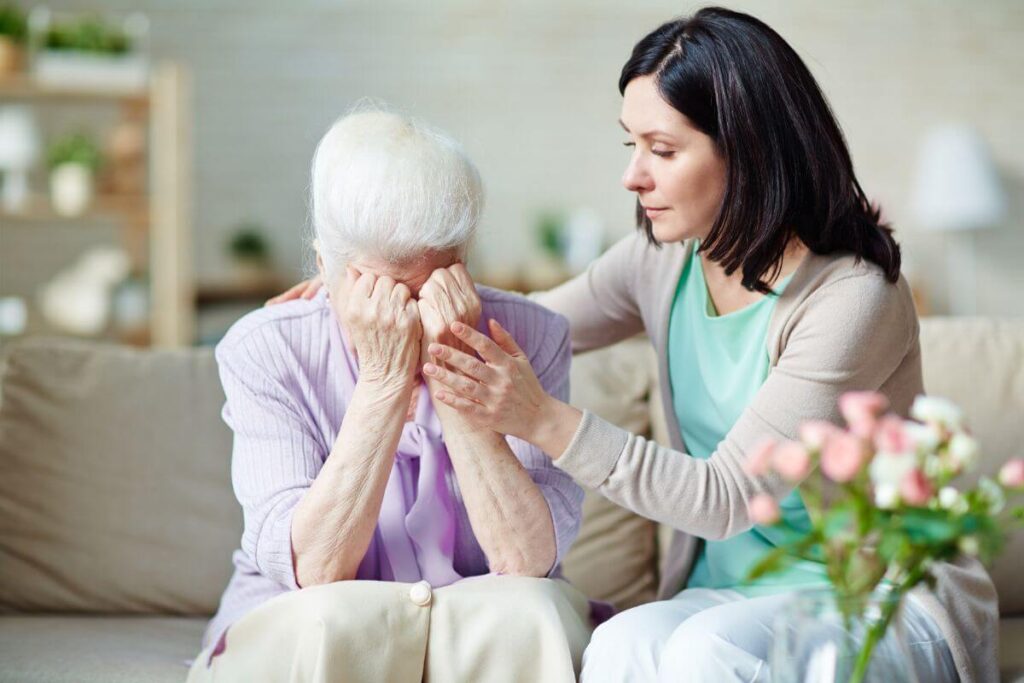 a middle age woman comforts an elderly woman who has lost her spouse and realizes grief is just love with no place to go