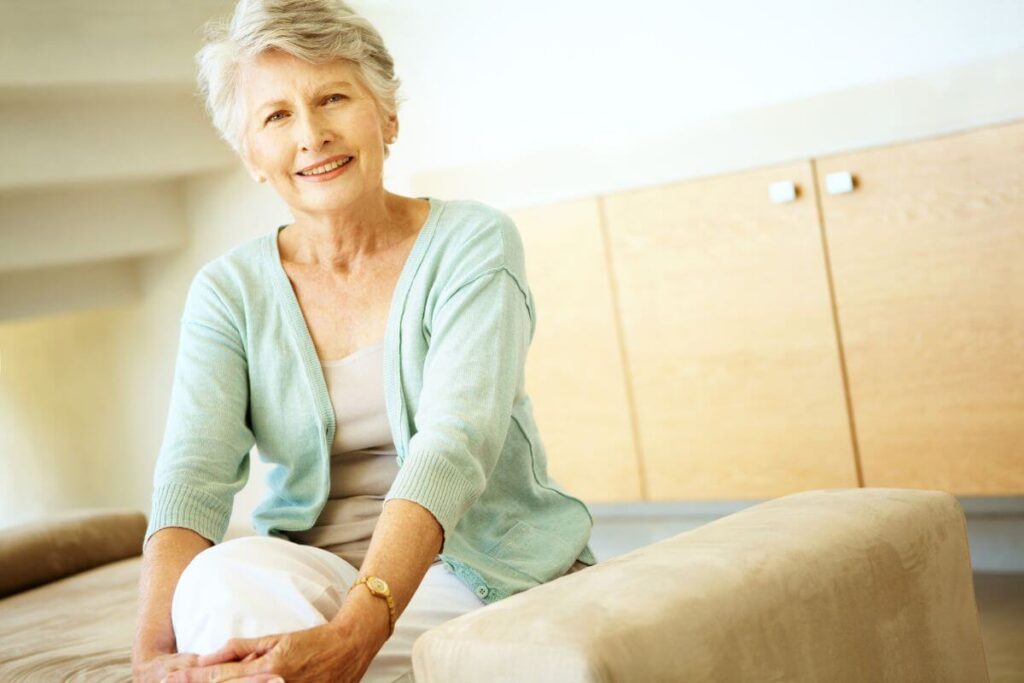 older woman peacefully smiles at the camera because she has achieved peace of mind