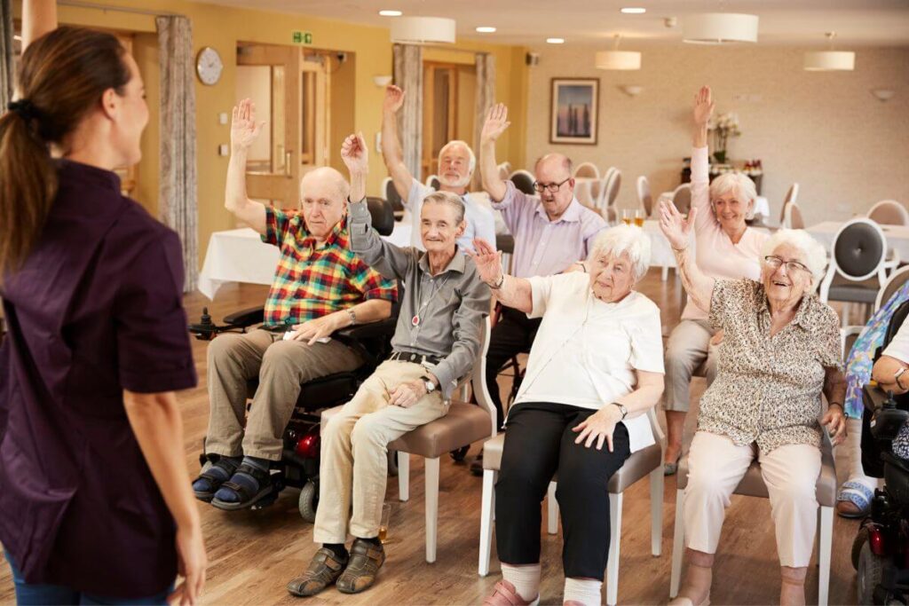 a group of elderly folks enjoy an exercise session at their assisted living center