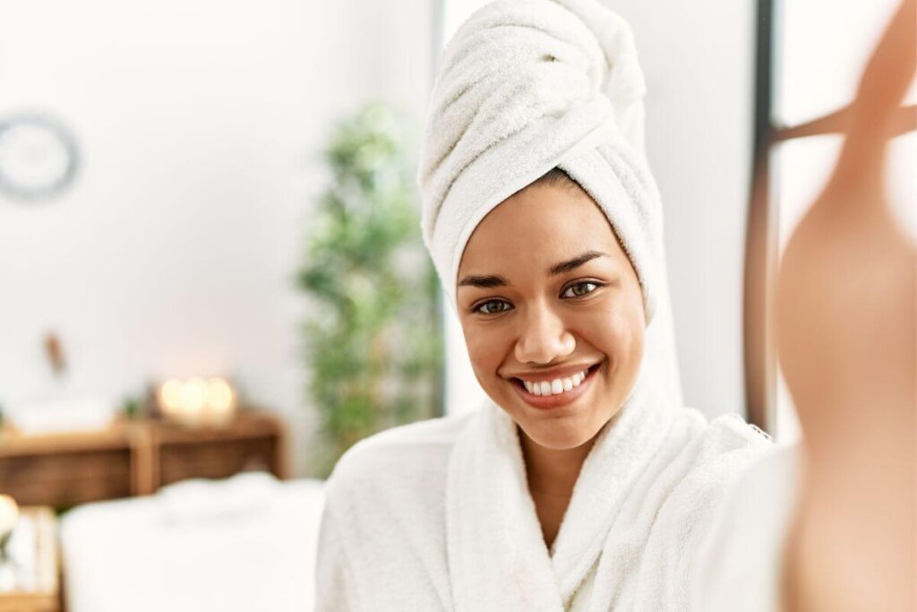 beautiful Black woman who has been feeling trapped caring for elderly parents takes time for quality self care and relaxes in her robe after a bath