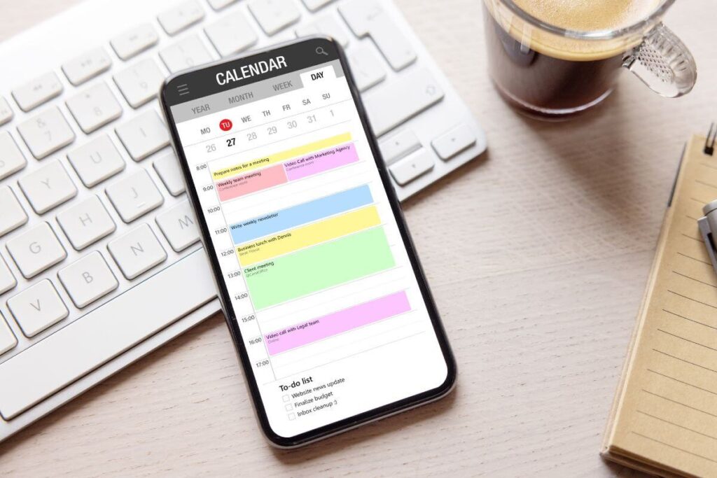 top view of a smart phone laying on a desk with a calendar app on the display