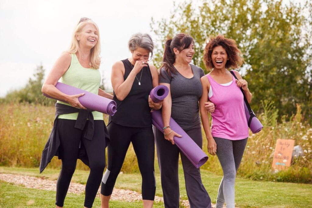 four women over 50 walk away from their yoga session in the park