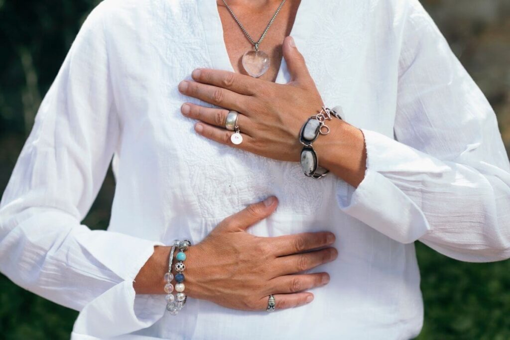 the front of a middle-aged woman holding her hands over her chest to show she is grateful and blessed