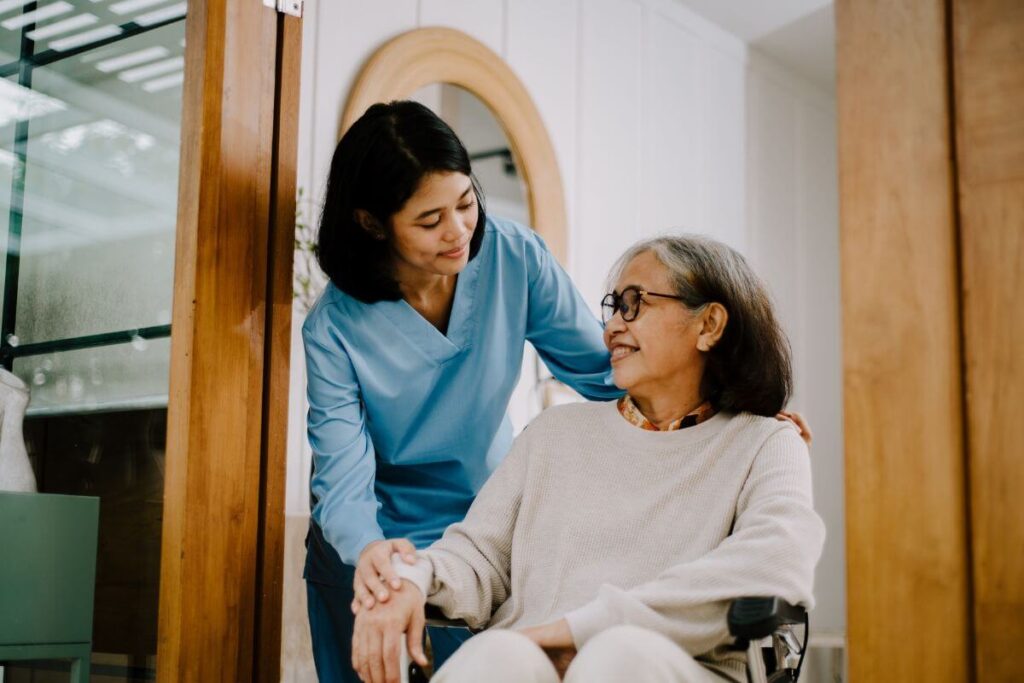 a hospice nurse assists a patient sitting in a wheelchair