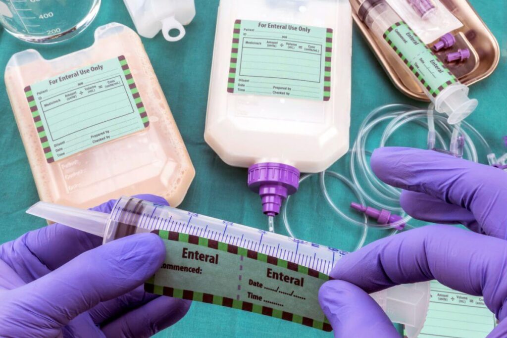 a top view of hands wearing purple latex gloves working with medical supplies