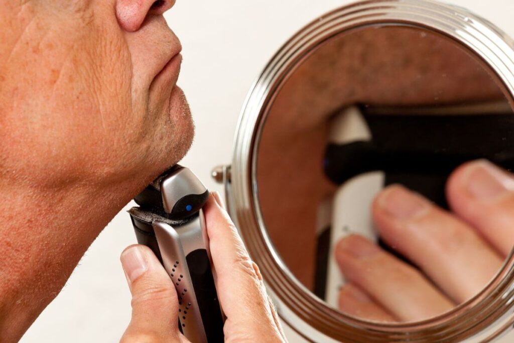 close up of a senior man using an electric razor, just one of many senior care items to improve hygiene and quality of life