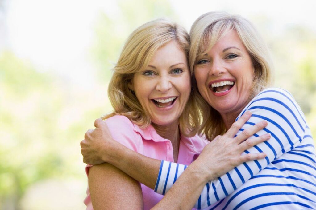 two middle aged women joyfully hug each other and demonstrate their meaningful friendship