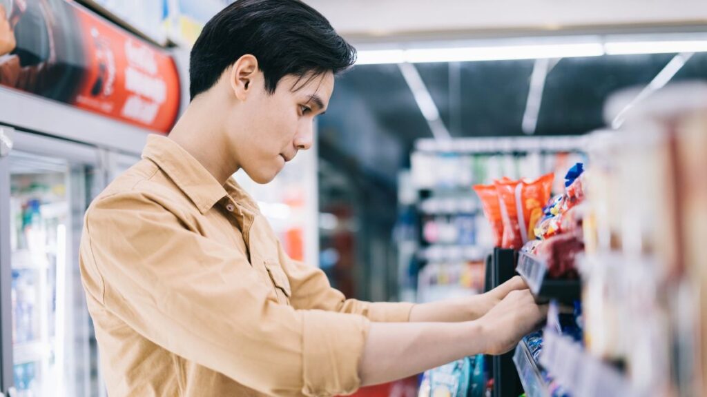 man looking at items in grocery store