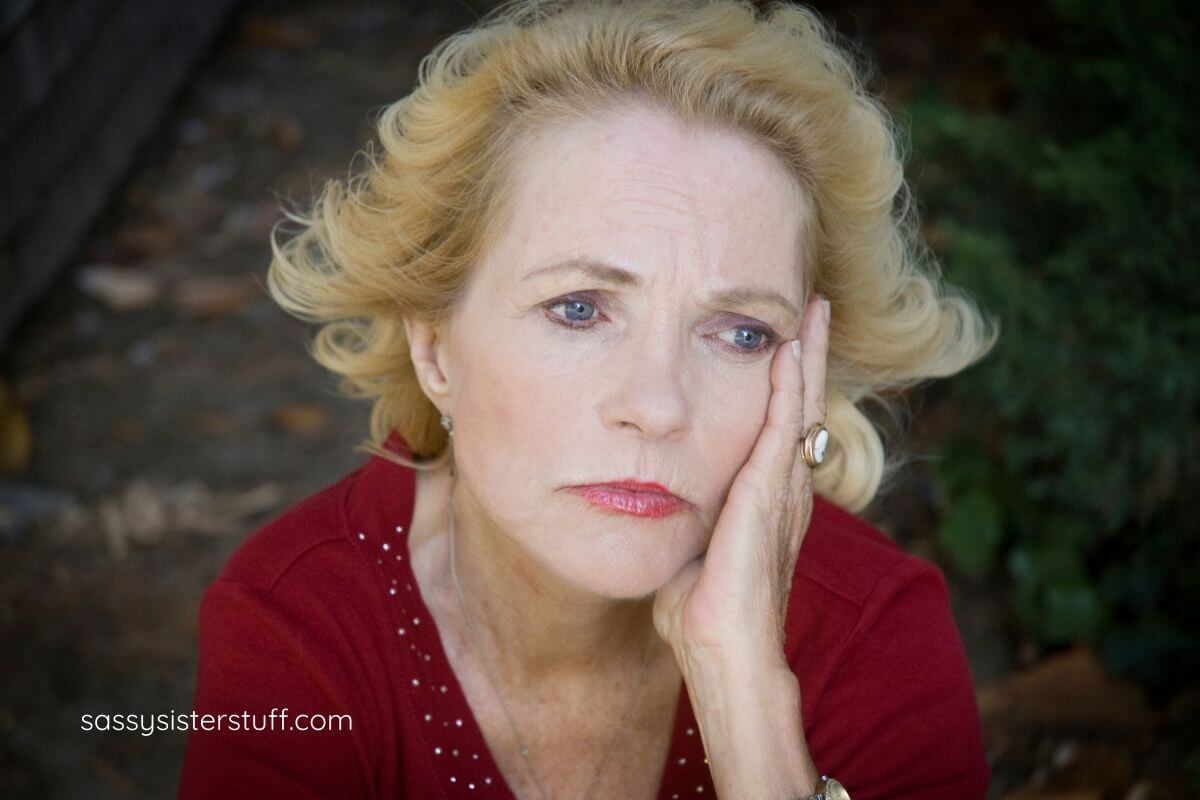 sad woman with head resting on her hand.