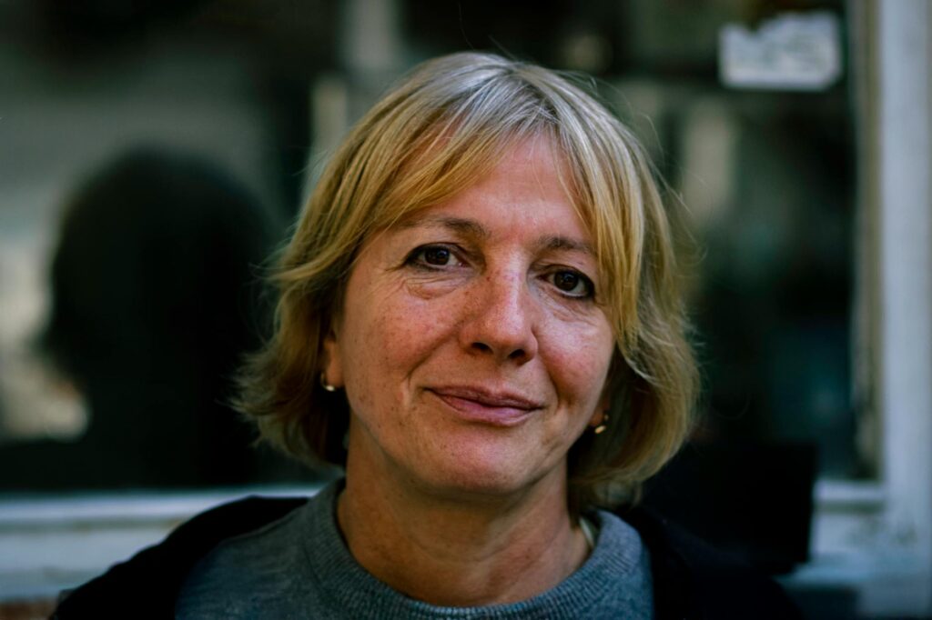 A_candid_portrait_of_a_senior_woman_with_short_blonde_hair,_outdoors_in_natural_light..Adem_Erkoç