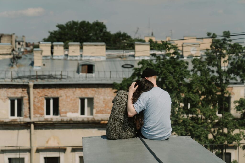 A_couple_sits_on_a_rooftop,_enjoying_a_romantic_moment_with_a_cityscape_view..cottonbro_studio