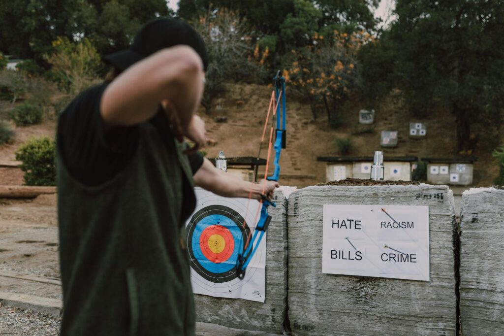 A person targets social issues with arrows symbolizing a fight against hate, racism, crime, and bills.