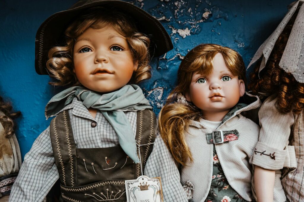 Charming vintage porcelain dolls dressed in rustic attire, perfect for collectors.