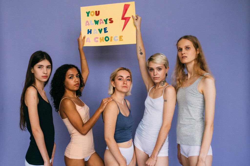 Group_of_diverse_women_standing_together_holding_a_motivational_sign..Viktoria__Slowikowska
