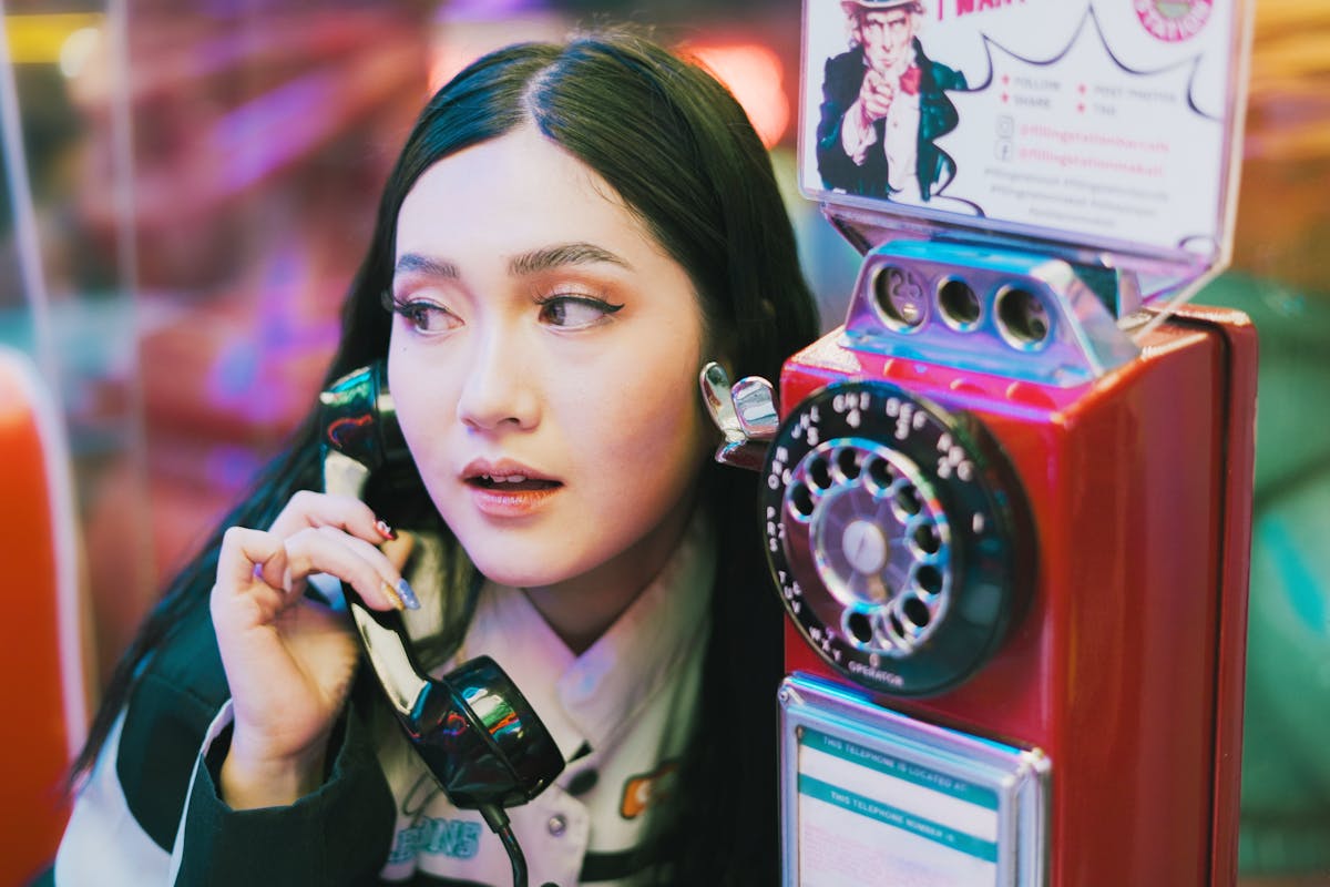 Woman Talking on a Retro Pay Phone