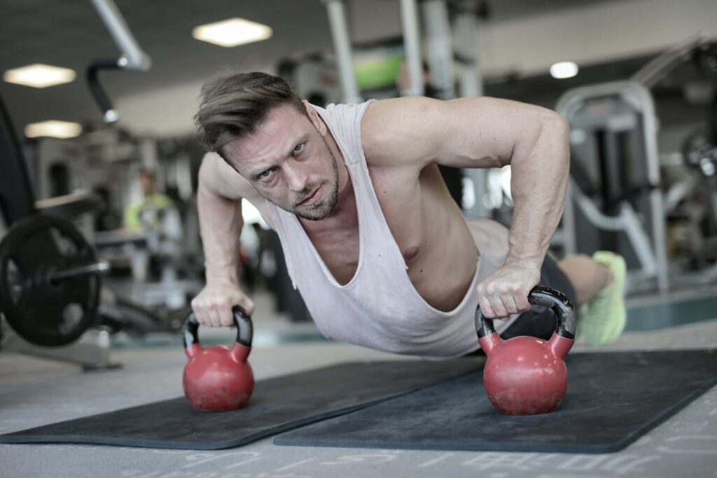 Determined strong sportsman doing push ups in gym