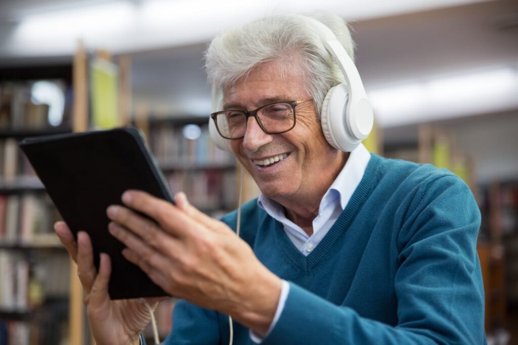 A Man in Blue V Neck Sweater Wearing White Headphones