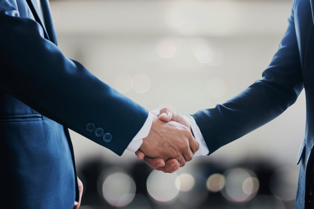 Persons in Black Suit Shaking Hands