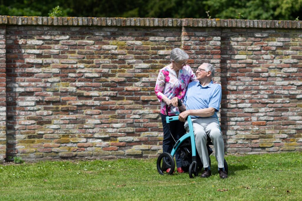 Smiling Elderly Couple on Lawn near House