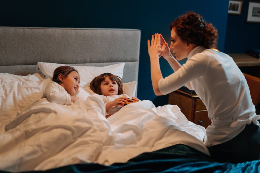 A Woman Story Telling with Two Children in Bed
