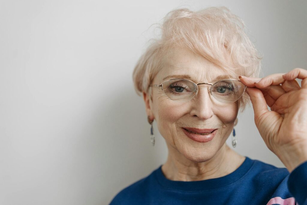 Portrait of a cheerful elderly woman wearing eyeglasses with a gentle smile.