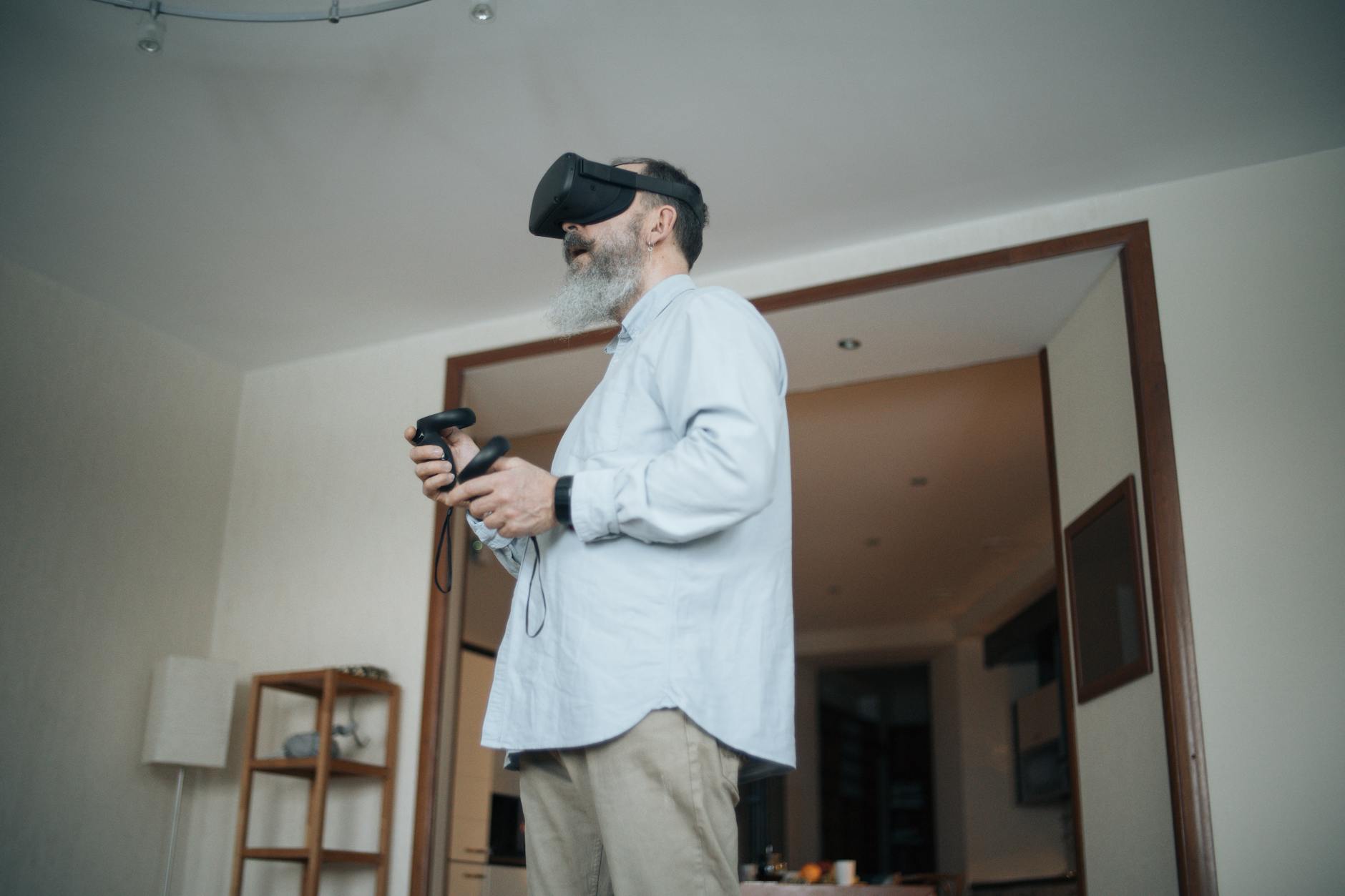 Senior adult man using virtual reality headset in a cozy living room setting.Mikhail Nilov 1