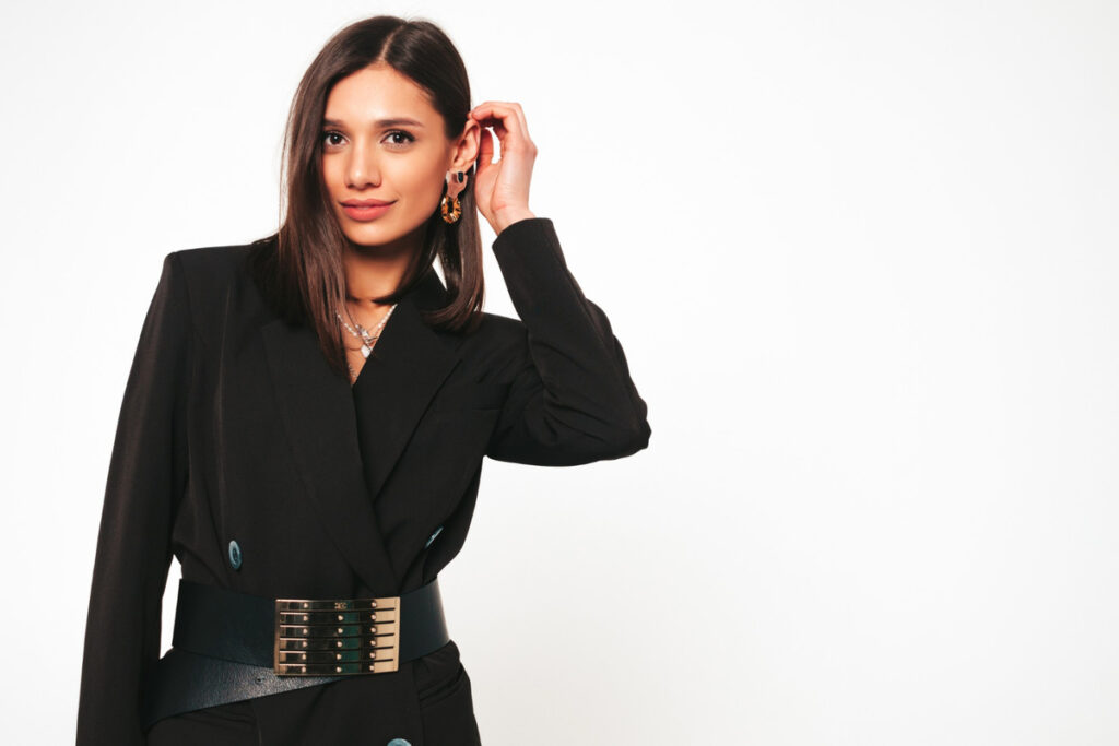Young beautiful smiling brunette female in nice trendy black business suit