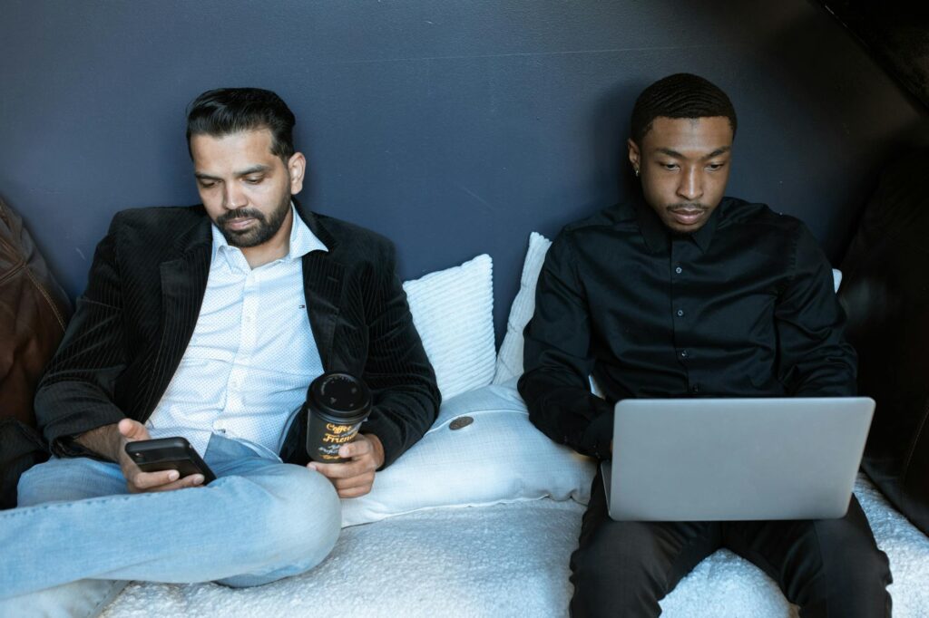Two business professionals working on a laptop and phone in a cozy office space.