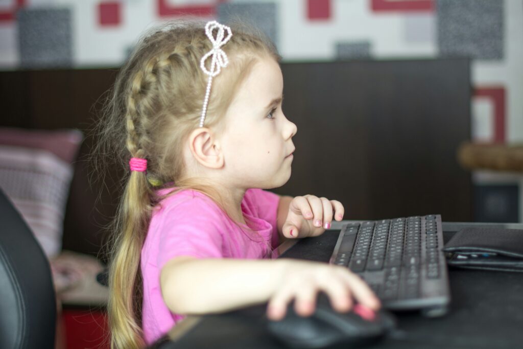 a_little_girl_sitting_in_front_of_a_computer_keyboard.Bermix_Studio