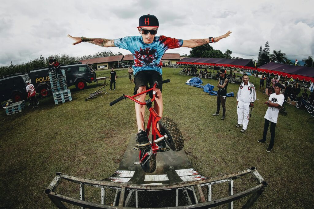 boy doing bicycle tricks in front of many people