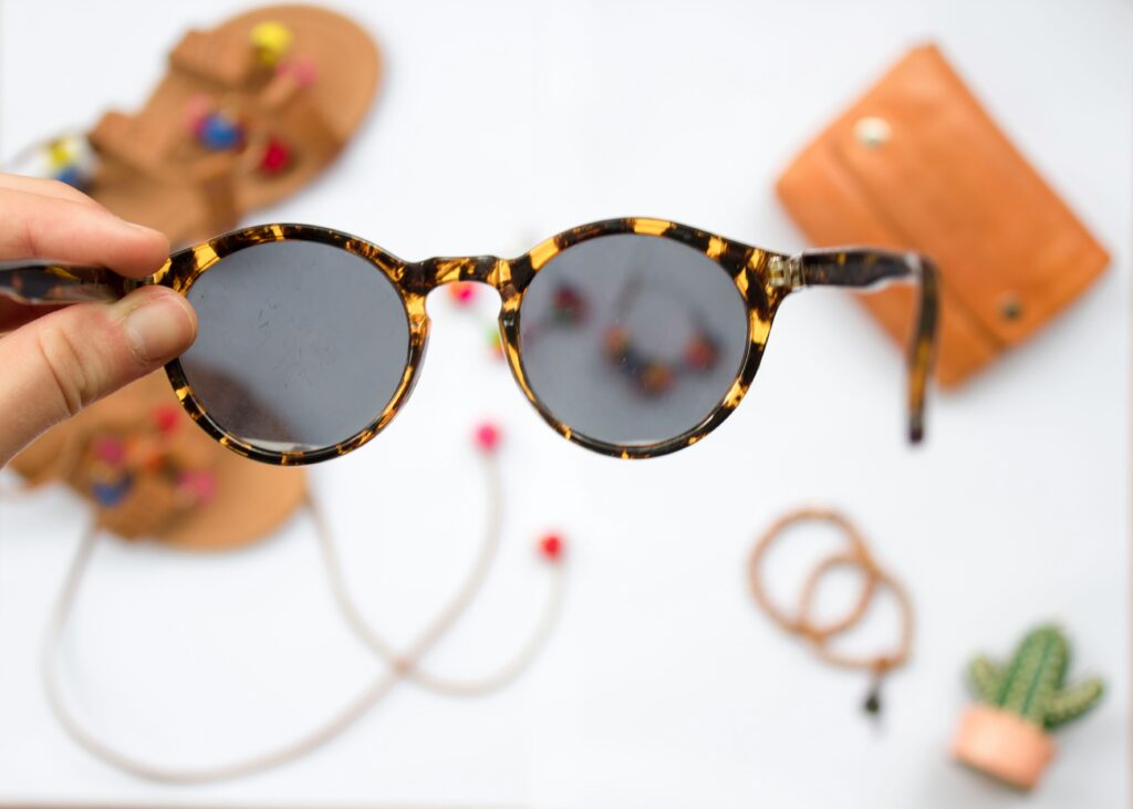 person_holding_brown_framed_sunglasses.S_O_C_I_A_L_._C_U_T