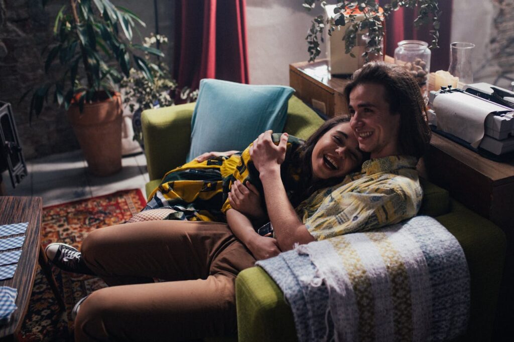 A Sweet Couple Hugging Each Other while Sitting on a Couch