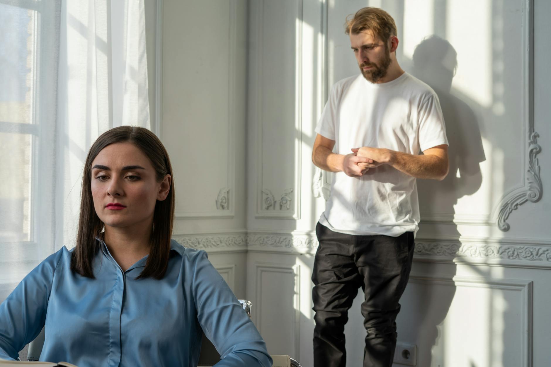 A couple struggles with emotional tension during a counseling session.