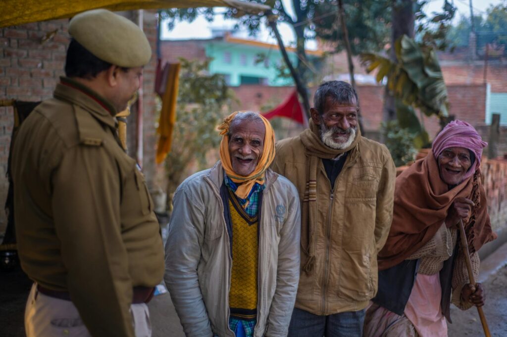 A heartwarming scene of elderly Indian people smiling with a police officer outdoors.