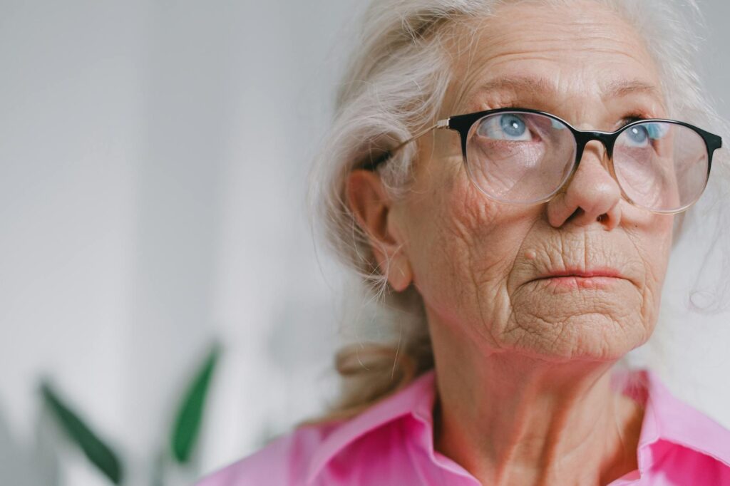 Close up portrait of a thoughtful elderly woman wearing glasses indoors.SHVETS production