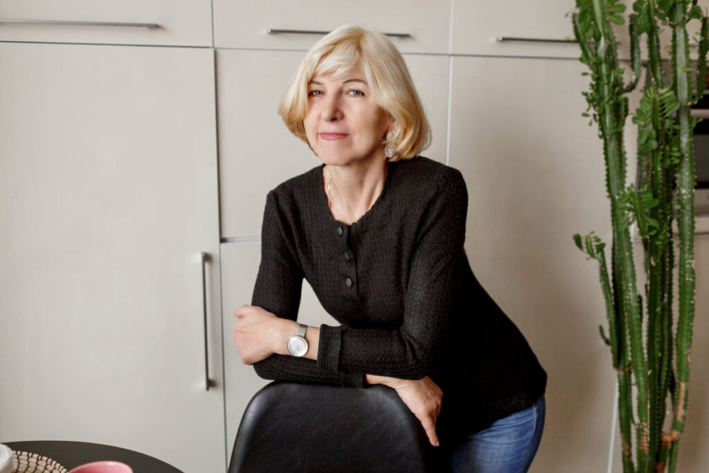Portrait of mature healthy slim woman posing in her modern kitchen