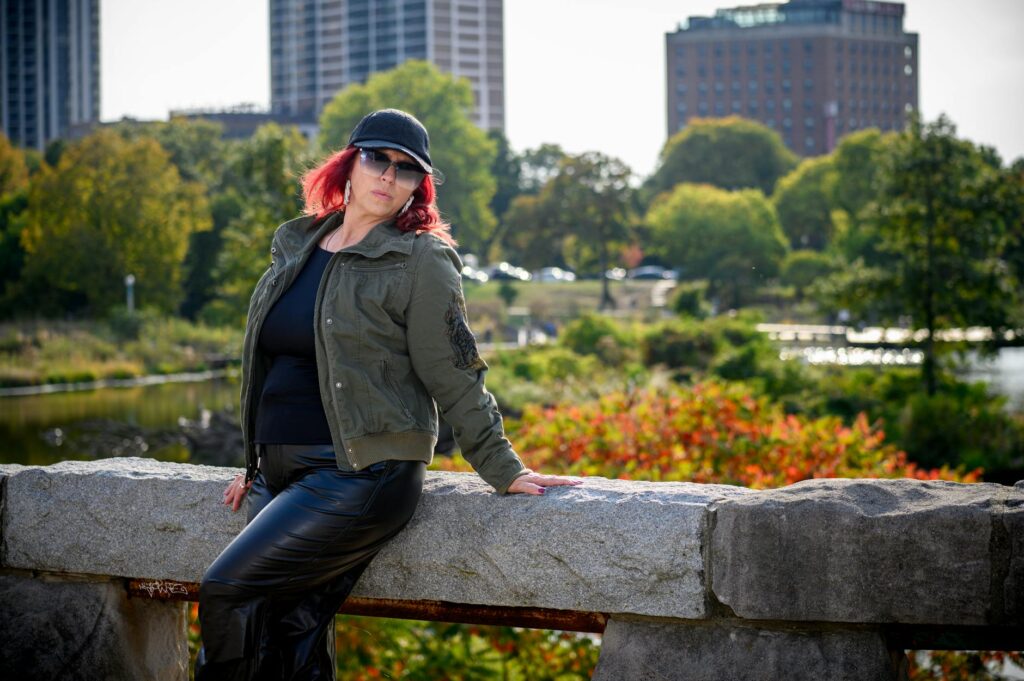 Fashionable woman poses with Chicago skyline backdrop in a vibrant autumn setting.
