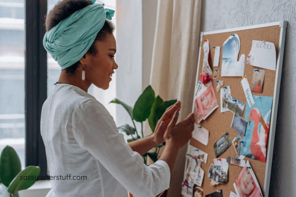 a woman reflects on her vision board to decide if she wants to make changes.