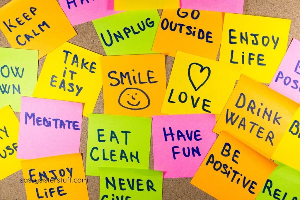 a vision board of sticky notes with inspirational messages written on them, scattered on a cork board.