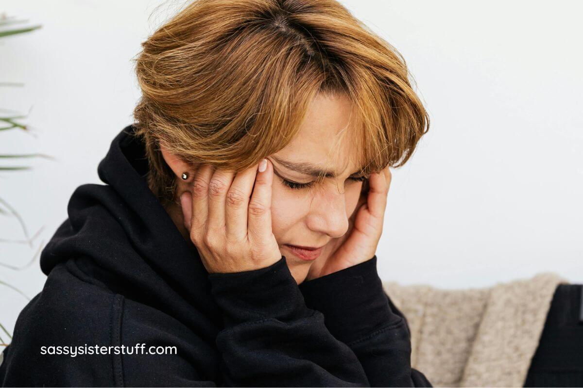 middled aged woman holds her temples because she is upset.