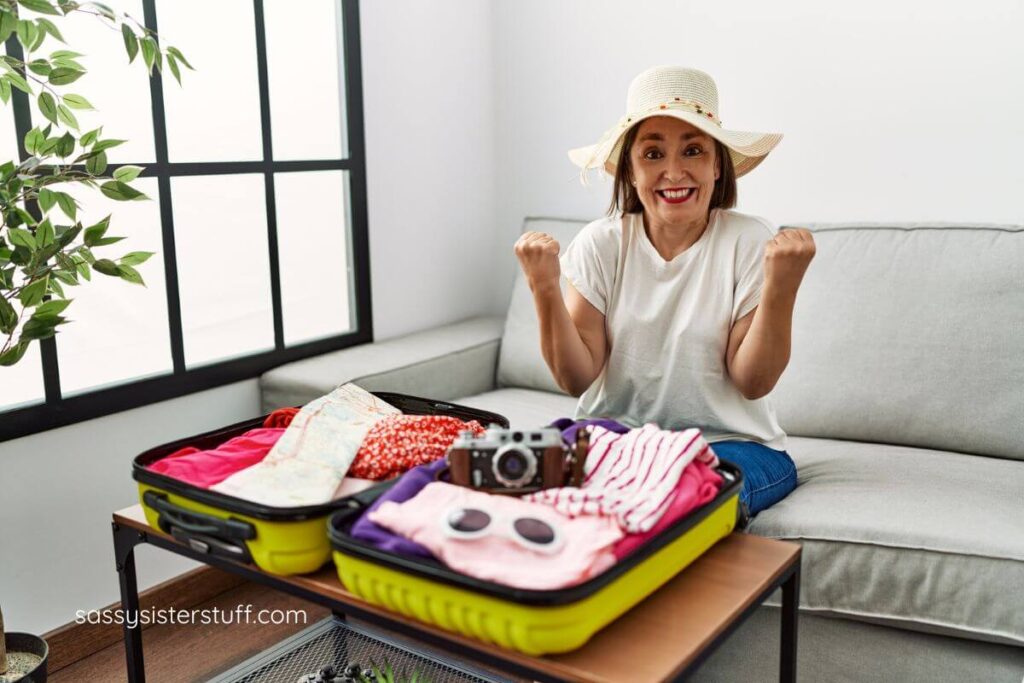 middle aged woman showing her neatly packed suitcase that she packed using a list of travel tips for woman over 50.