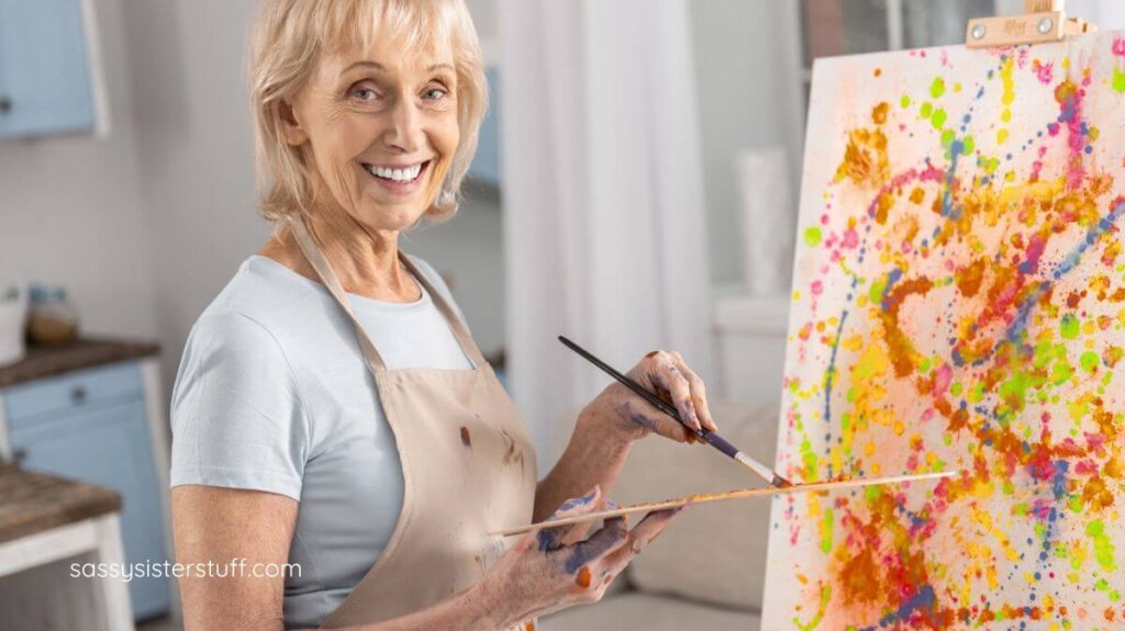 middle aged woman painting on an easel.
