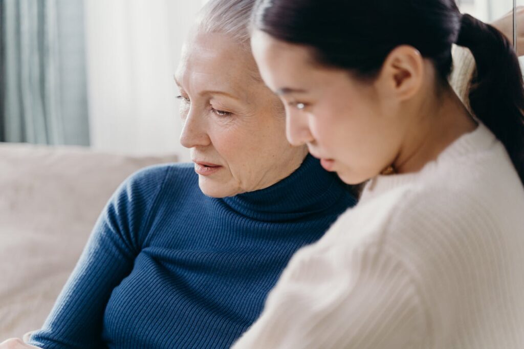 Elderly Woman in Blue Shirt Beside a Woman in White