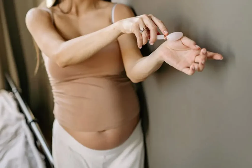 A Pregnant Woman Massaging Her Hand with a Stone Roller
