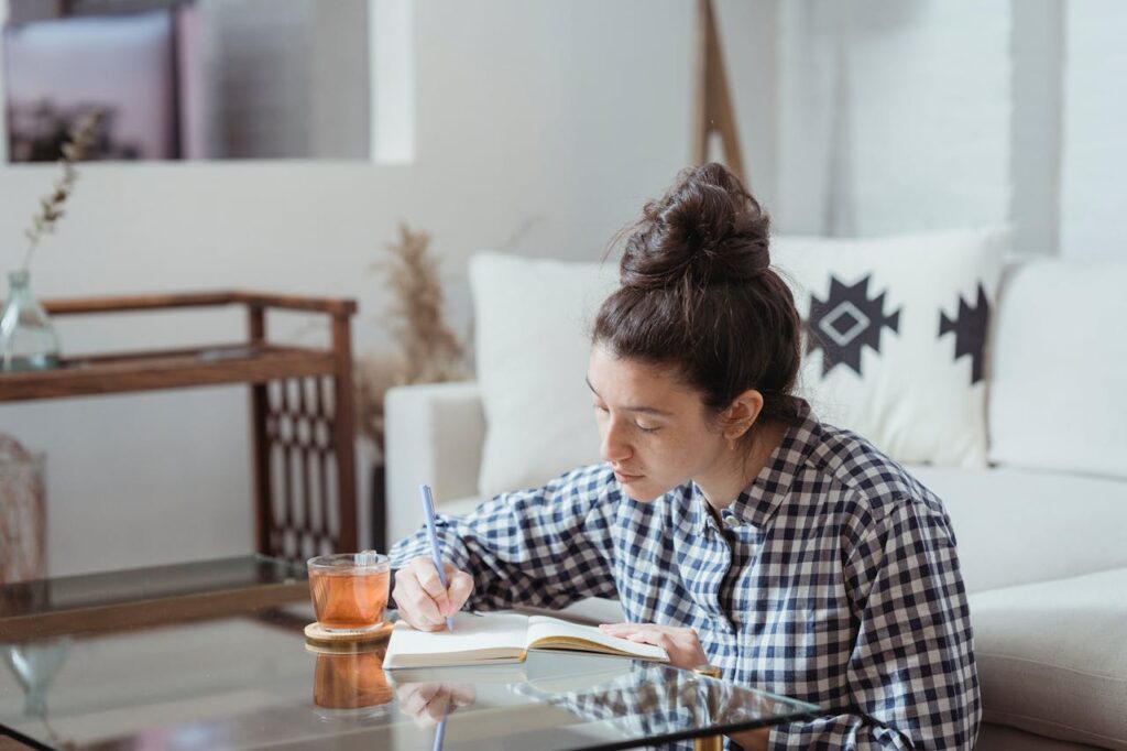 Woman in Shirt Writing in Notebook