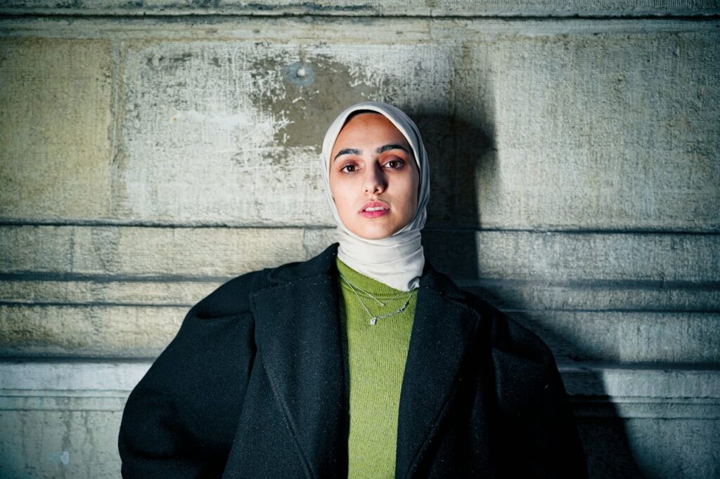 Confident Woman in Hijab Against Stone Wall
