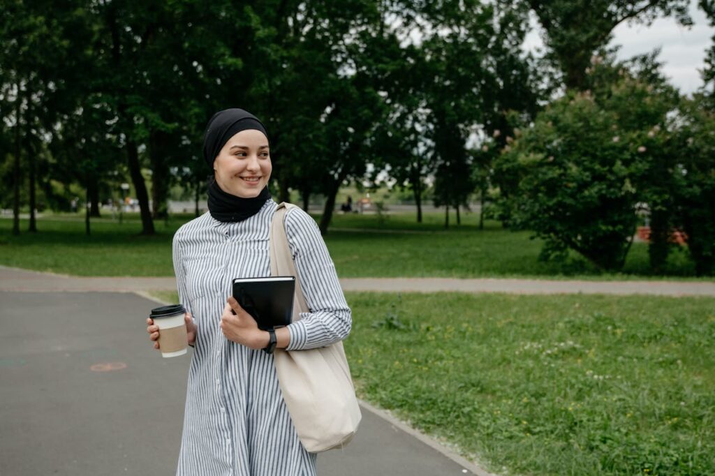 Young Woman with Coffee and Notebook in the Park