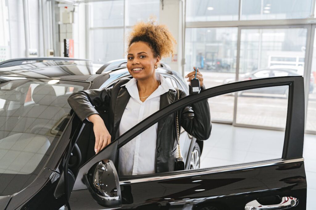 Woman in Black Blazer Standing Beside Black Car