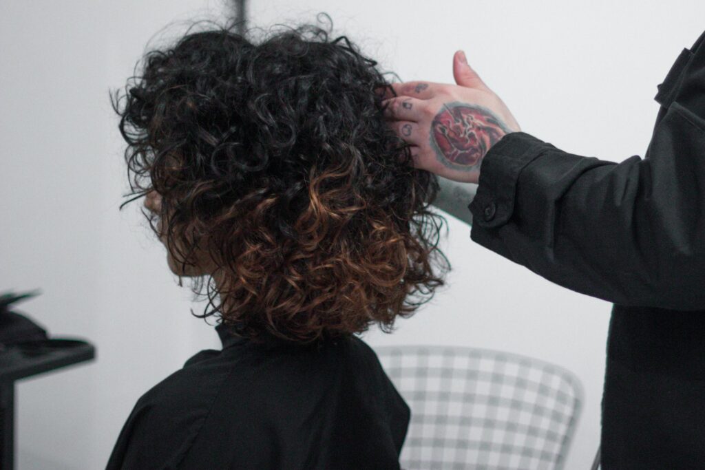 woman applying curl cream to natural curly hair